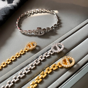 Elegant gold and silver link bracelet with pave zircon oval charm on a display tray
