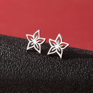 Boucles d'oreilles fleurs en acier inoxydable argenté sur un socle en cuir noirci
