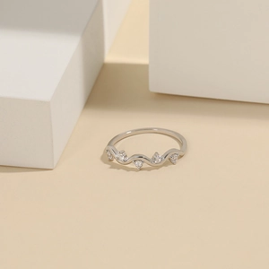 Macro detail of wave-shaped S925 silver ring set with five sparkling white zircons