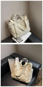 Detail view of cream quilted tote bag showing diamond stitching and side pocket design