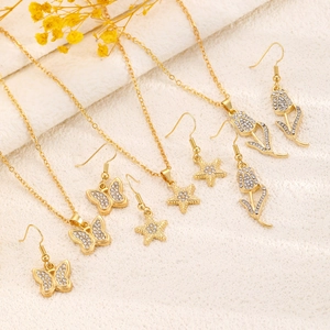 Macro detail of gold plated jewelry set featuring crystal butterfly and star designs