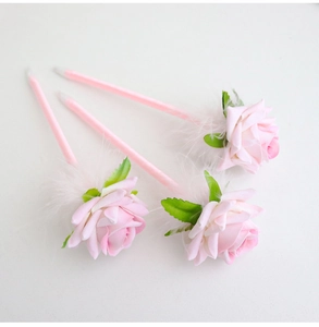 Three creative pink rose pens with soft white feathers and decorative green leaves