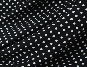 Macro shot of French style black lace polka dot fabric showing soft textile texture