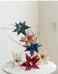 Gros plan de poinsettias de Noël en velours premium avec bords pailletés sur table