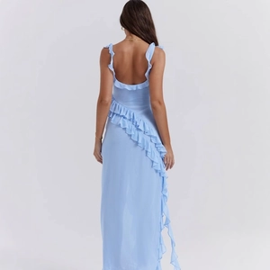 Detail of light blue backless dress featuring elegant ruffled edges and deep V-back