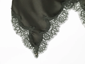 Gros plan sur le tissu en satin noir avec dentelle délicate et texture de luxe