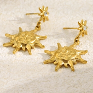 Détail de boucles d'oreilles soleil rétro en acier doré 18 carats avec des zircons