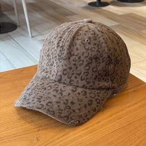 Detailed close-up of leopard print baseball cap with distressed brim and corduroy texture
