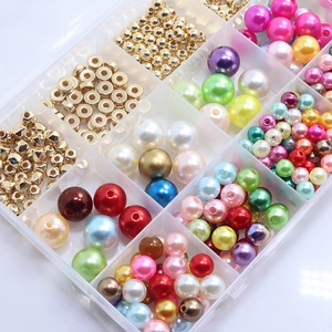 Close-up of DIY jewelry kit with colorful ABS faux pearls and gold spacer beads in a box