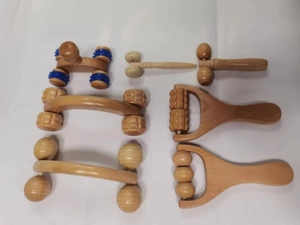 Detailansicht verschiedener Holzmassagerollen und Werkzeuge für die manuelle Therapie