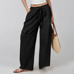 Detail of drawstring elastic waist and cargo side pockets on black wide-leg cotton pants
