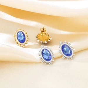 Detail of vintage oval earrings featuring blue gemstones and small white pearls on satin