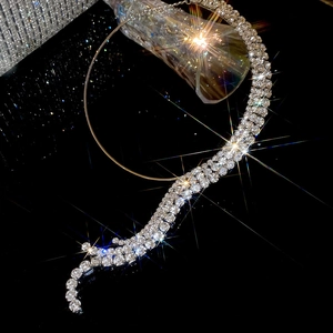 Macro shot of multi-row silver rhinestone necklace showing flexible S-shaped design on black