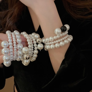 Detail of elegant multilayer pearl bracelet set with silver and black beads on wrist