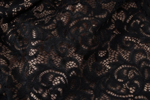 Gros plan sur le tissu en dentelle florale noire aux textures creuses translucides fines