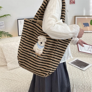Detailed view of striped plush tote bag featuring a cute white happy dog patch on furry material