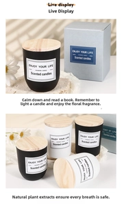 Detail of frosted black and white glass scented candles with natural wood lids and gift boxes