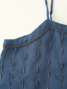 Detailed macro view of dark blue camisole neckline with intricate black beadwork