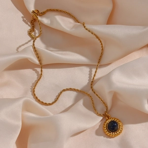 Détail d'un collier avec pendentif en agate noire plaqué or 18 carats sur soie