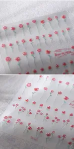 Détail macro de stickers ongles 3D en relief avec roses roses, paillettes et feuilles