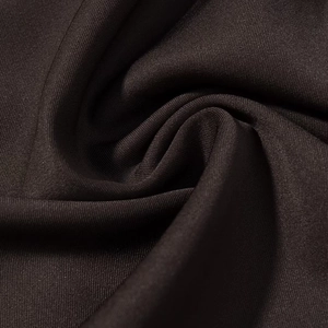 Vista macro del tessuto marrone scuro del vestito con trama liscia e pieghe morbide