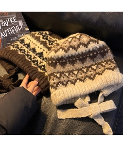 Detail of vintage Fair Isle knit hats with earflaps in coffee and beige colors