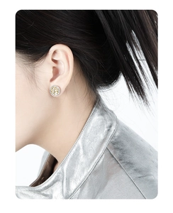 Detail of S925 silver stud earring with gold mesh texture worn on a person