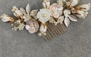 Detailed close-up of bridal hair comb with gold leaves and ceramic flowers
