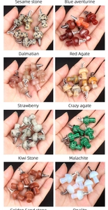 Detailed view of assorted natural stone mushroom pendants held in hand for size context