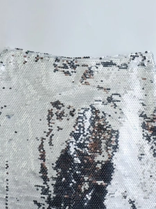 Dettaglio della trama di paillettes argento su questa elegante gonna longuette con spacco