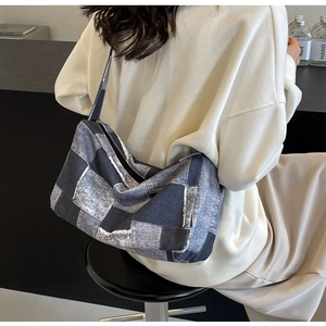 Sac bandoulière en denim patchwork porté par un mannequin dans un cadre décontracté