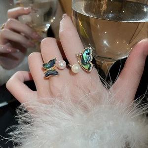 Detail of gold butterfly ring featuring freshwater pearls and abalone shell inlay