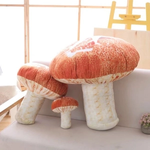 Set of three soft plush mushroom pillows in large, medium and small sizes on a sofa