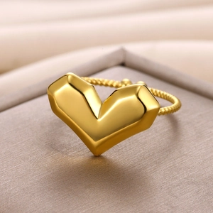 Detail of 18k gold heart ring featuring twisted band and polished texture close-up