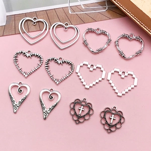 Detailed flat lay of assorted vintage silver hollow heart charms for DIY jewelry making