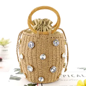 Straw bucket bag with sparkling rhinestones, round handles and drawstring lining