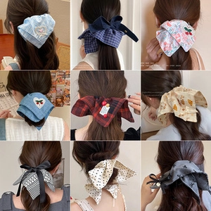 Collage of diverse bow hair ties featuring plaid, floral, and polka dot textile patterns