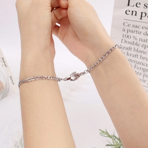 Matching silver magnet hand-holding bracelets for couples with sleek cuban chain design