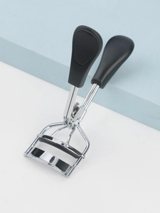 Close-up of portable stainless steel eyelash curler with ergonomic black non-slip handle
