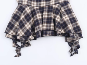 Detailed view of layered ruffles and asymmetric hem on a classic blue plaid skirt