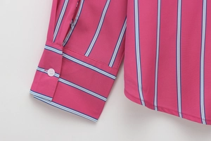 Detailed shot of rose pink striped shirt cuff with white button and woven texture