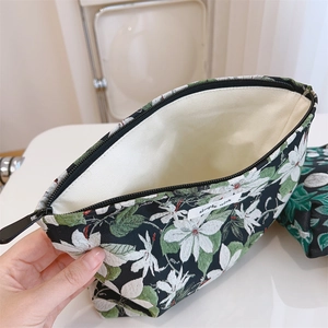 Macro shot of floral cosmetic bag with black zipper and spacious beige lining interior