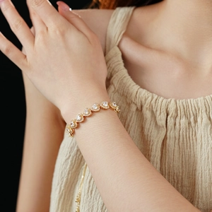 Close-up of golden double-layer heart zircon bracelet with adjustable slider clasp