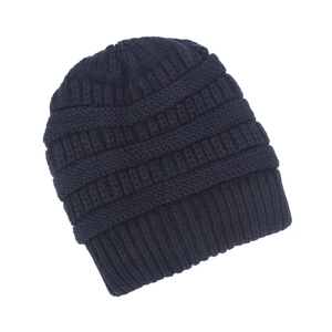 Detail of dark blue cable knit beanie showing thick texture and ribbed fold-over cuff
