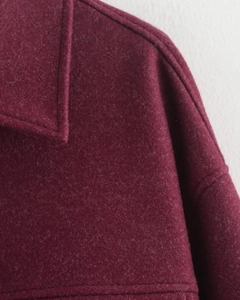 Gros plan du revers et des coutures de ce manteau en laine bordeaux au style vintage
