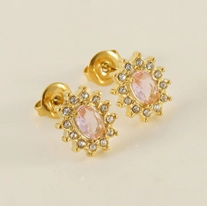 Détail macro de boucle d'oreille dorée 18K avec gemme rose et halo de cristaux