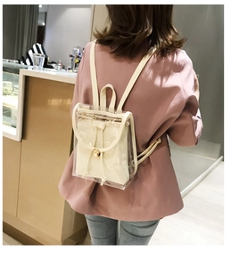 Rear view of a transparent PVC backpack with a cream drawstring pouch on model