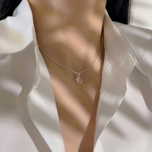 Detailed close-up of 18k gold plated hollow square pendant necklace on model neck