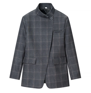 Détail d'un blazer gris à carreaux avec col montant, bouton unique et coupe asymétrique