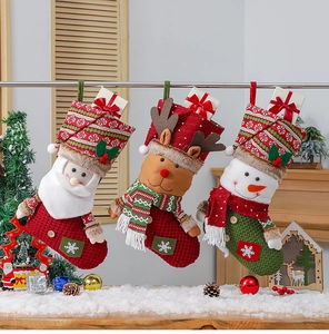 Vue détaillée de trois chaussettes de Noël tricotées avec Père Noël, Renne et Bonhomme de neige